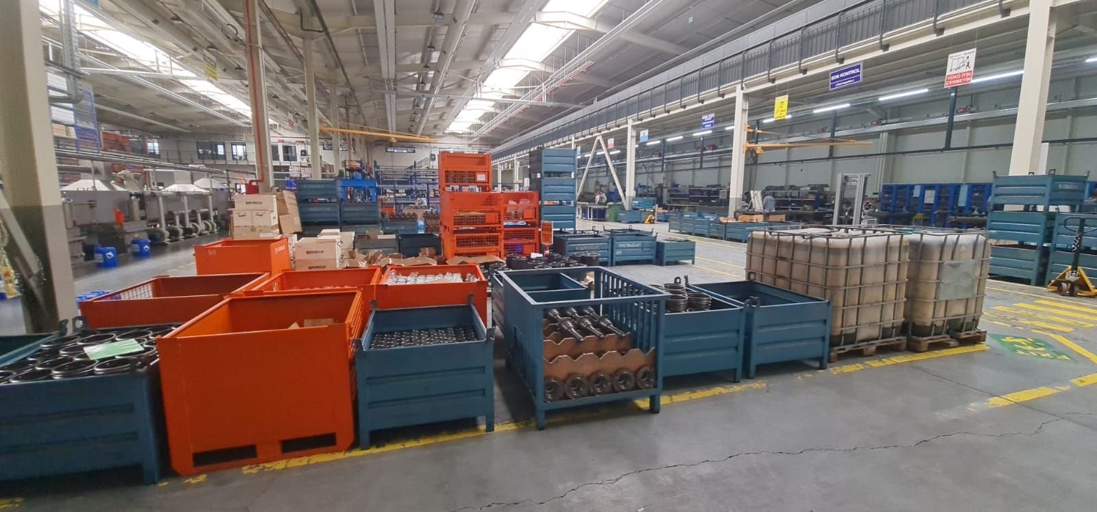 Pièces métalliques dans des caisses-palettes en usine, prêtes à être enlevées